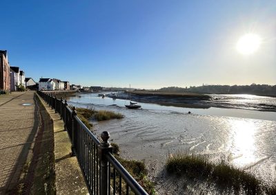 A picture of Wivenhoe Quay during the day - clear blue sky and the sun is shining